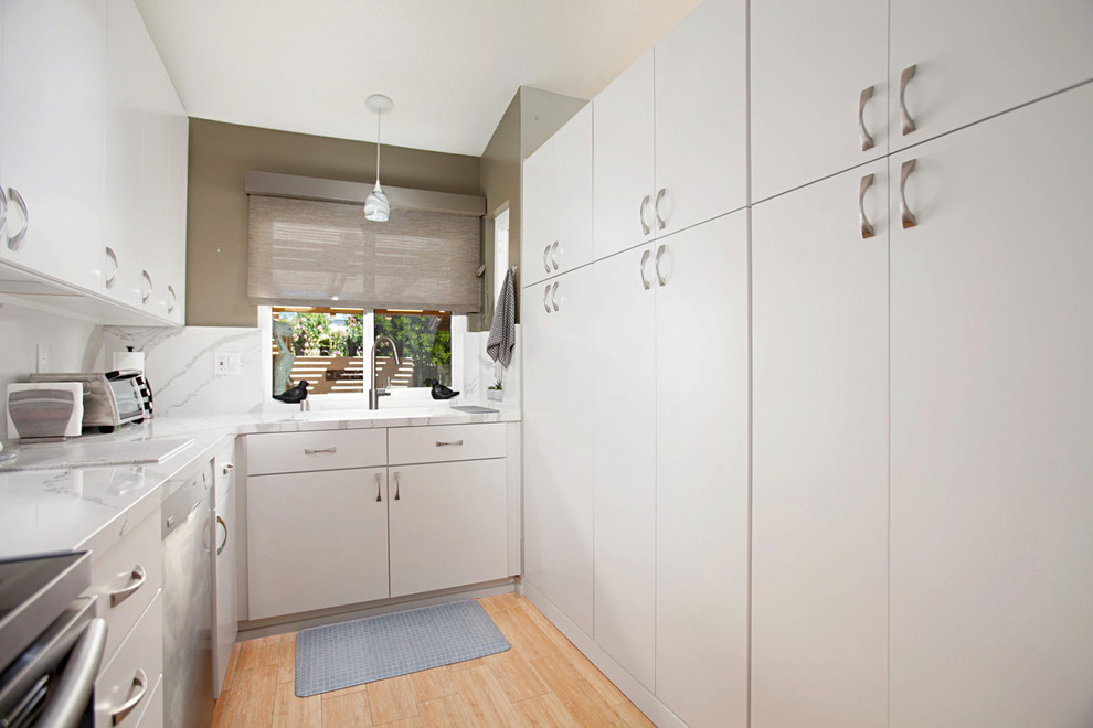 Foto på ett litet funkis kök, med en dubbel diskho, släta luckor, vita skåp, bänkskiva i kvarts, vitt stänkskydd, stänkskydd i sten, rostfria vitvaror, klinkergolv i porslin och beiget golv