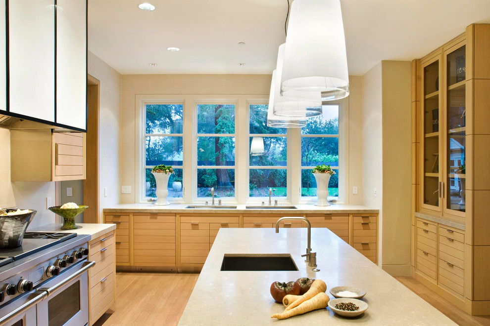 サンフランシスコにあるコンテンポラリースタイルのおしゃれな独立型キッチン (フラットパネル扉のキャビネット、シルバーの調理設備、淡色木目調キャビネット) の写真