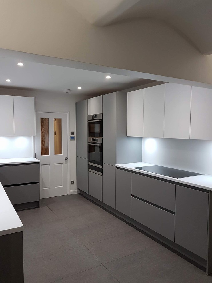 Photo of a medium sized contemporary u-shaped enclosed kitchen in London with flat-panel cabinets and composite countertops.