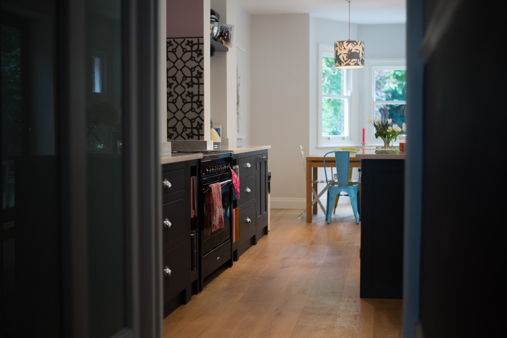 Design ideas for a medium sized classic kitchen/diner in London with a belfast sink, shaker cabinets, dark wood cabinets, dark hardwood flooring and an island.