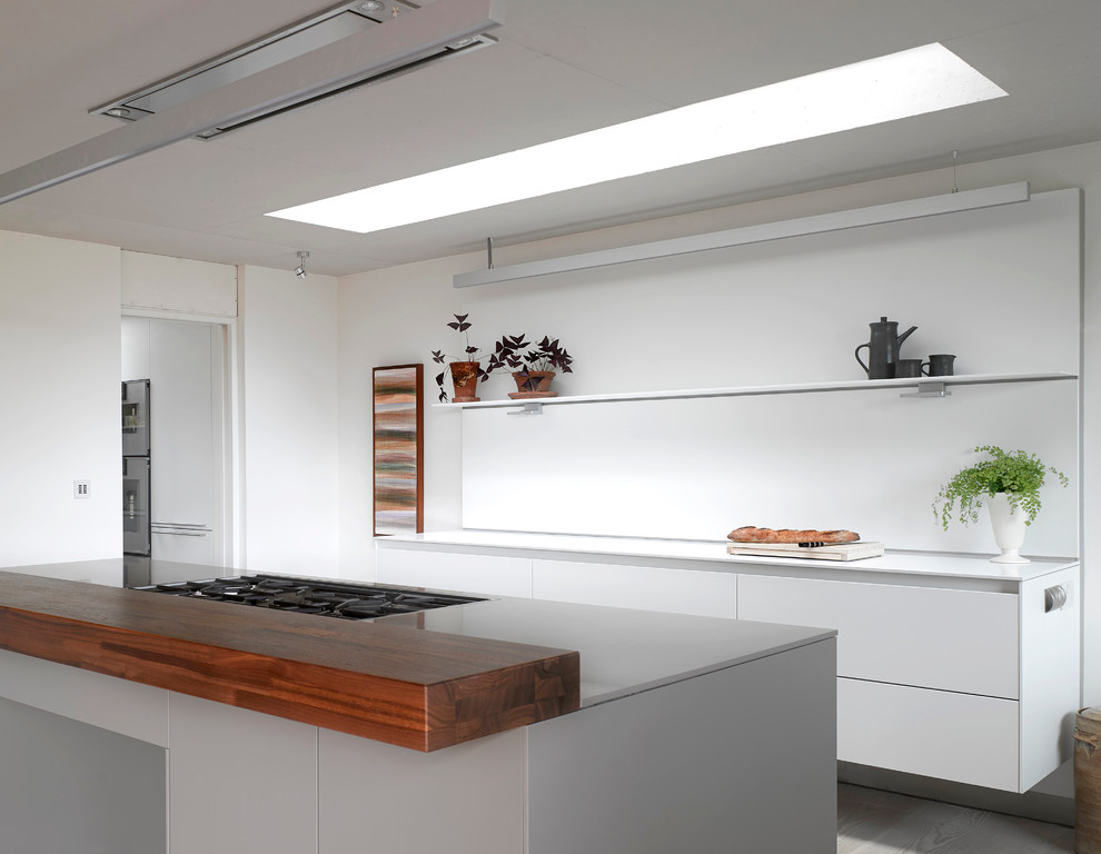 Foto de cocina contemporánea de tamaño medio abierta con puertas de armario blancas, salpicadero blanco, suelo de madera pintada y una isla