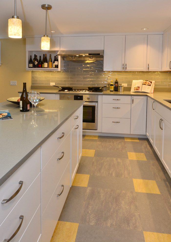 Inspiration for a mid-sized modern l-shaped linoleum floor open concept kitchen remodel in Seattle with an undermount sink, recessed-panel cabinets, white cabinets, quartz countertops, gray backsplash, ceramic backsplash, stainless steel appliances and an island