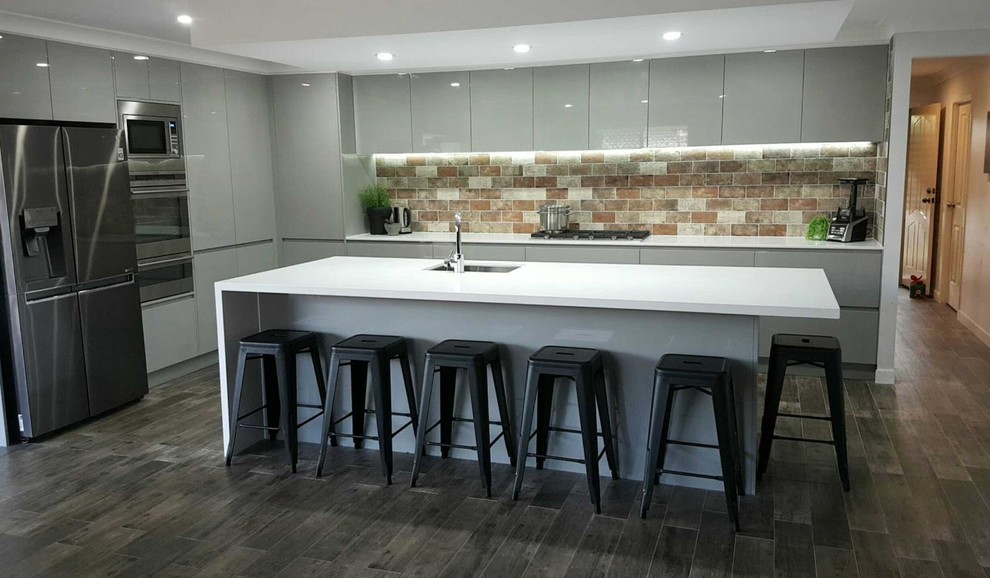 Photo of a rustic l-shaped kitchen in Brisbane with composite countertops, brick splashback and an island.