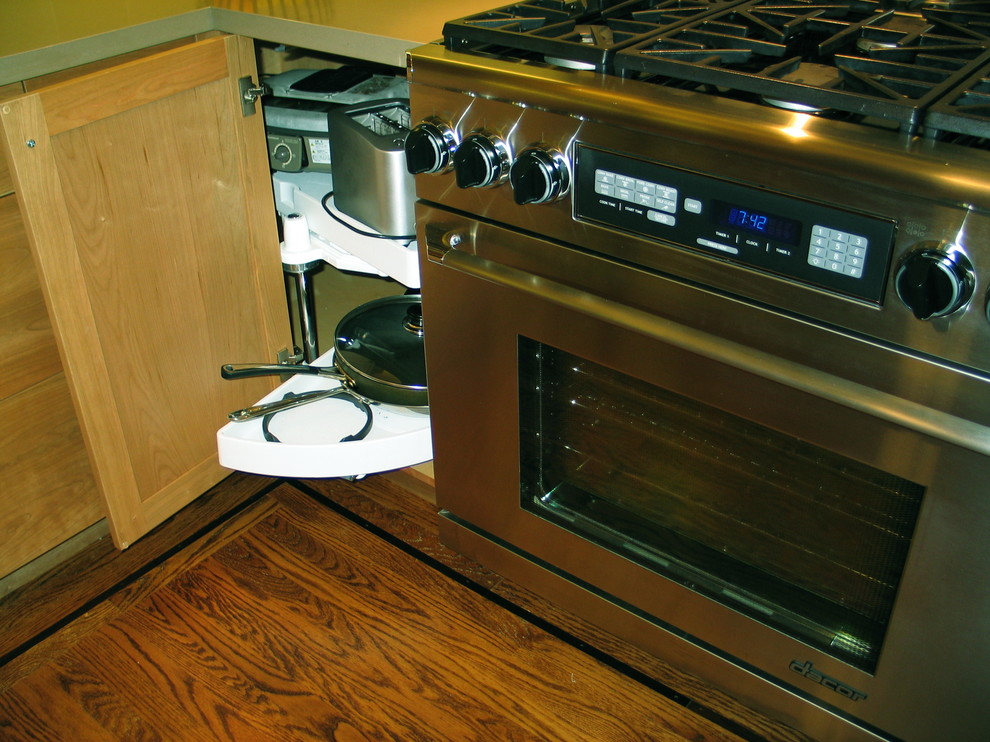 Immagine di una piccola cucina contemporanea con lavello sottopiano, ante lisce, ante in legno scuro, elettrodomestici in acciaio inossidabile, parquet scuro, nessuna isola e pavimento marrone