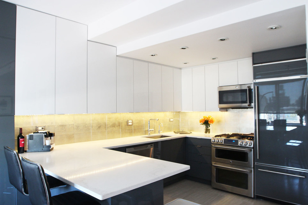 Photo of a medium sized contemporary u-shaped kitchen/diner in New York with a submerged sink, flat-panel cabinets, white cabinets, engineered stone countertops, metallic splashback, glass tiled splashback, stainless steel appliances, porcelain flooring and a breakfast bar.