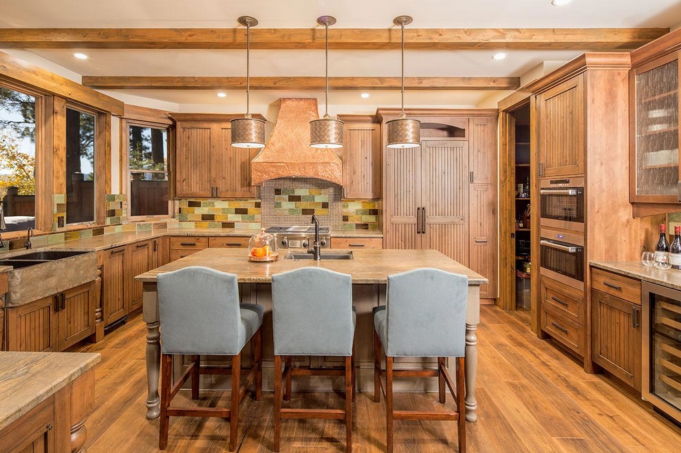 Klassisk inredning av ett stort kök, med en rustik diskho, luckor med upphöjd panel, skåp i mellenmörkt trä, granitbänkskiva, flerfärgad stänkskydd, stänkskydd i stenkakel, rostfria vitvaror, mellanmörkt trägolv och en köksö