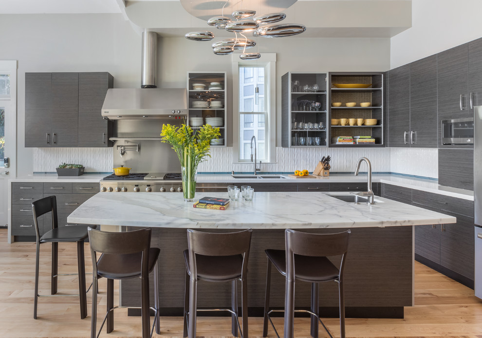 Photo of a large contemporary u-shaped enclosed kitchen in San Francisco with flat-panel cabinets, grey cabinets, marble worktops, white splashback, ceramic splashback, stainless steel appliances, medium hardwood flooring, an island and a double-bowl sink.