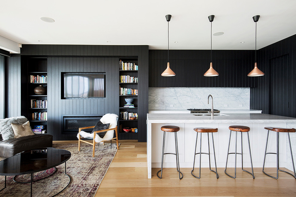 Offene Moderne Küche in L-Form mit Unterbauwaschbecken, Kassettenfronten, schwarzen Schränken, Küchenrückwand in Weiß, Küchengeräten aus Edelstahl, hellem Holzboden und Kücheninsel in Sydney