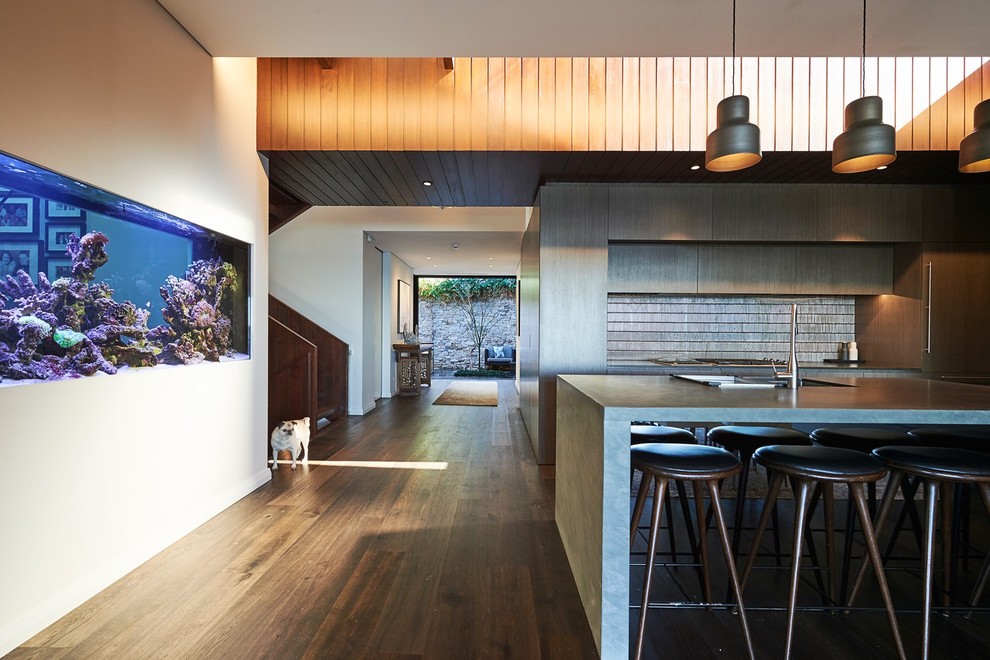 シドニーにあるコンテンポラリースタイルのおしゃれなアイランドキッチン (ダブルシンク、フラットパネル扉のキャビネット、グレーのキャビネット、グレーのキッチンパネル、濃色無垢フローリング、茶色い床、グレーのキッチンカウンター) の写真