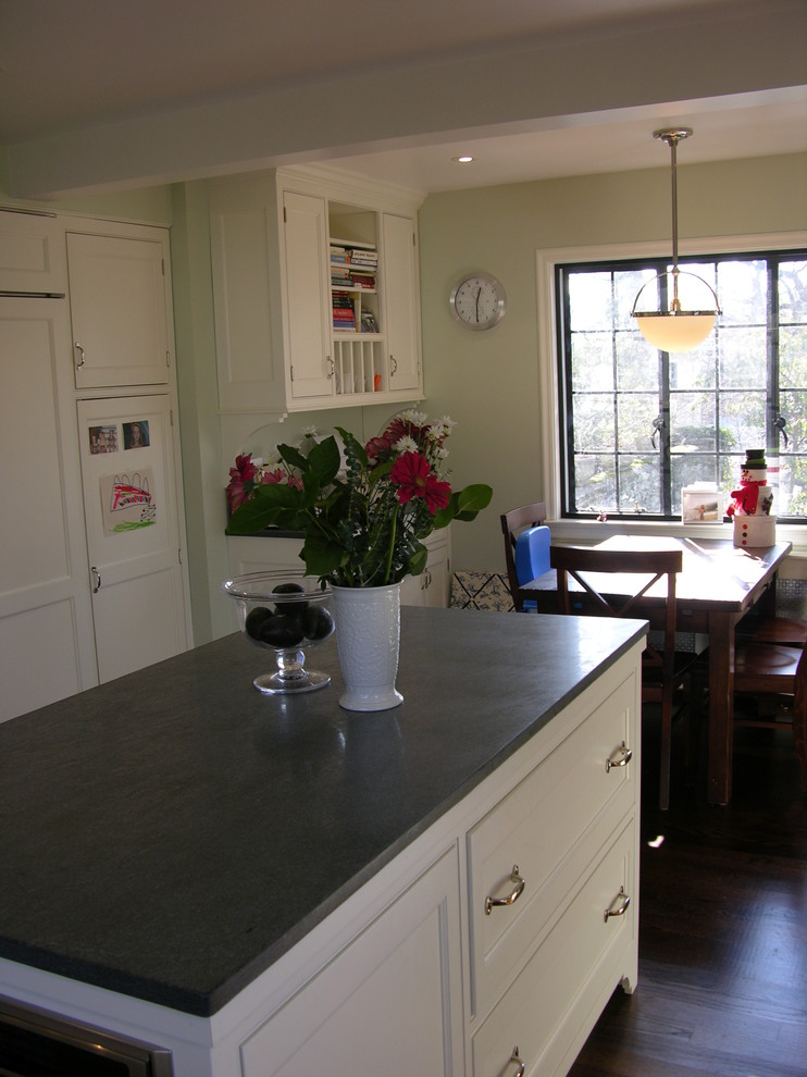 Foto di una cucina tradizionale di medie dimensioni con ante a filo, ante bianche, top in saponaria, elettrodomestici da incasso e parquet scuro