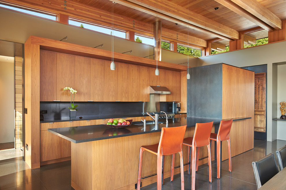 Свежая идея для дизайна: параллельная кухня-гостиная среднего размера в современном стиле с плоскими фасадами, фасадами цвета дерева среднего тона, черным фартуком и полуостровом - отличное фото интерьера