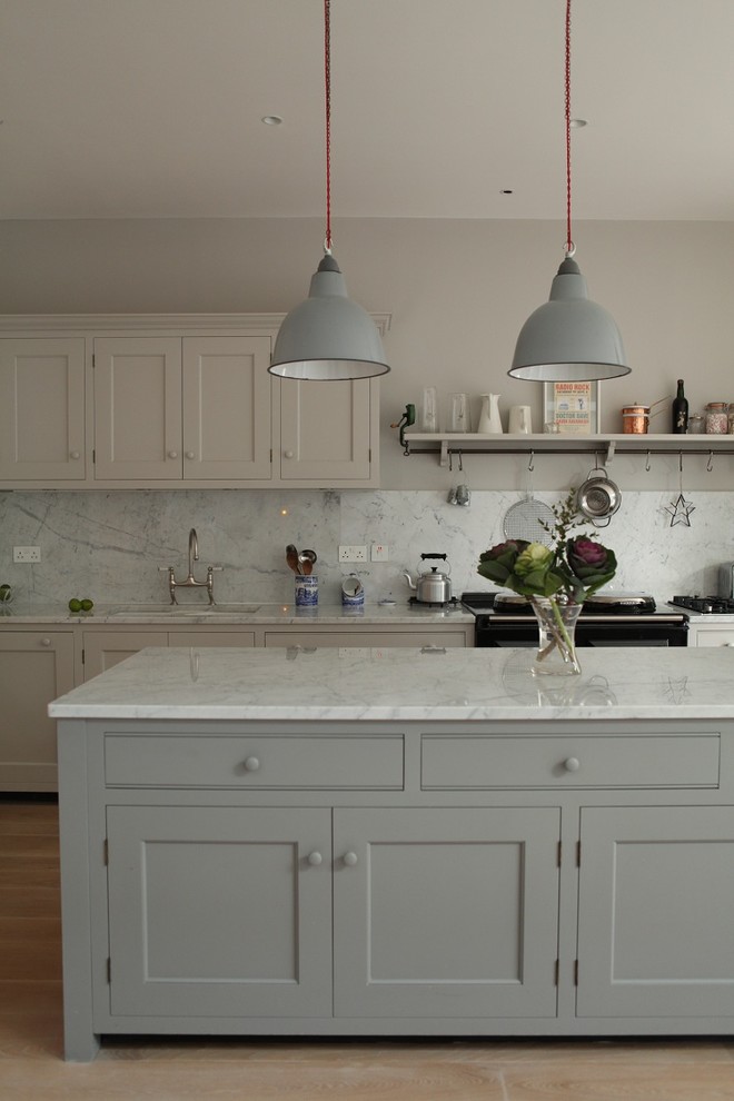 Esempio di una cucina chic di medie dimensioni con ante in stile shaker, ante grigie, top in marmo, elettrodomestici neri, paraspruzzi grigio, paraspruzzi in lastra di pietra e parquet chiaro