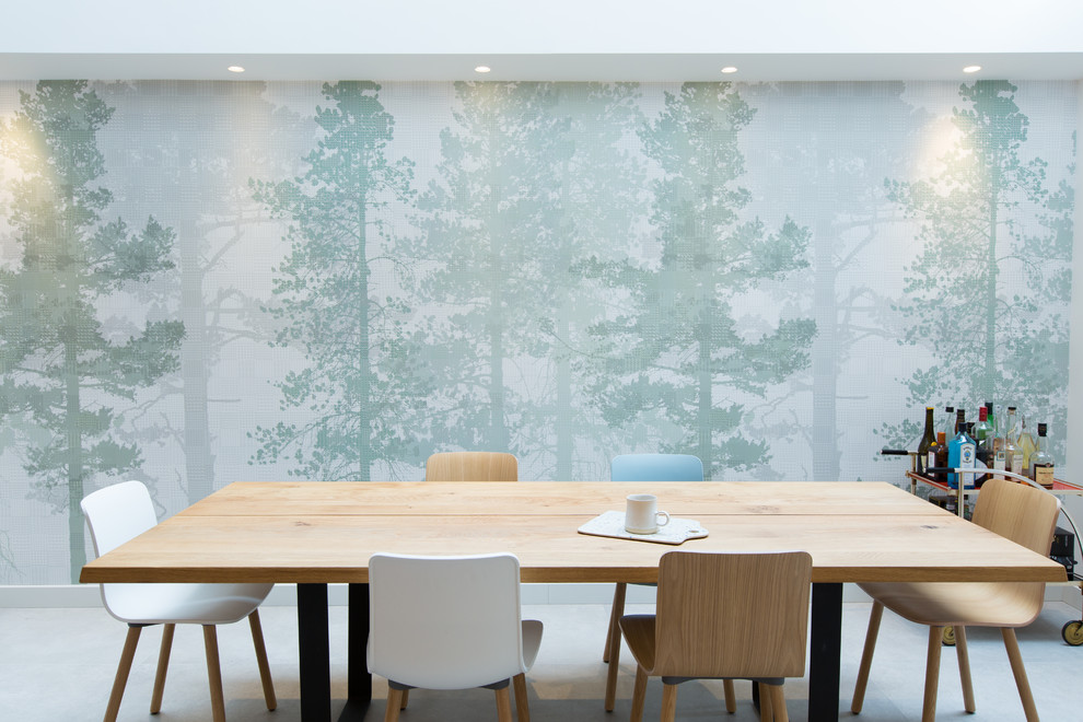 Immagine di un'ampia sala da pranzo aperta verso la cucina scandinava con pavimento in cemento, pavimento grigio, pareti verdi, nessun camino e carta da parati