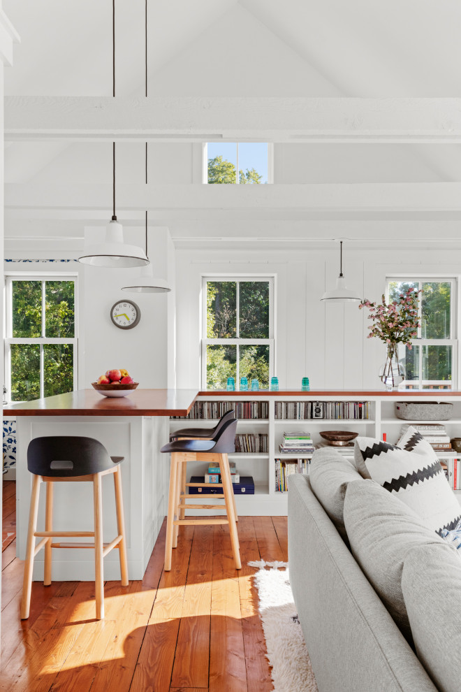 Foto på ett litet skandinaviskt vit kök, med en rustik diskho, luckor med infälld panel, vita skåp, bänkskiva i kvartsit, vitt stänkskydd, rostfria vitvaror, mellanmörkt trägolv och en halv köksö