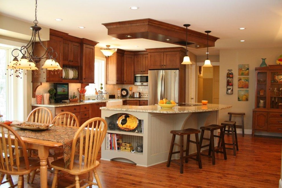 Example of a mid-sized classic l-shaped medium tone wood floor eat-in kitchen design in Milwaukee with a farmhouse sink, shaker cabinets, dark wood cabinets, granite countertops, white backsplash, ceramic backsplash, stainless steel appliances and an island