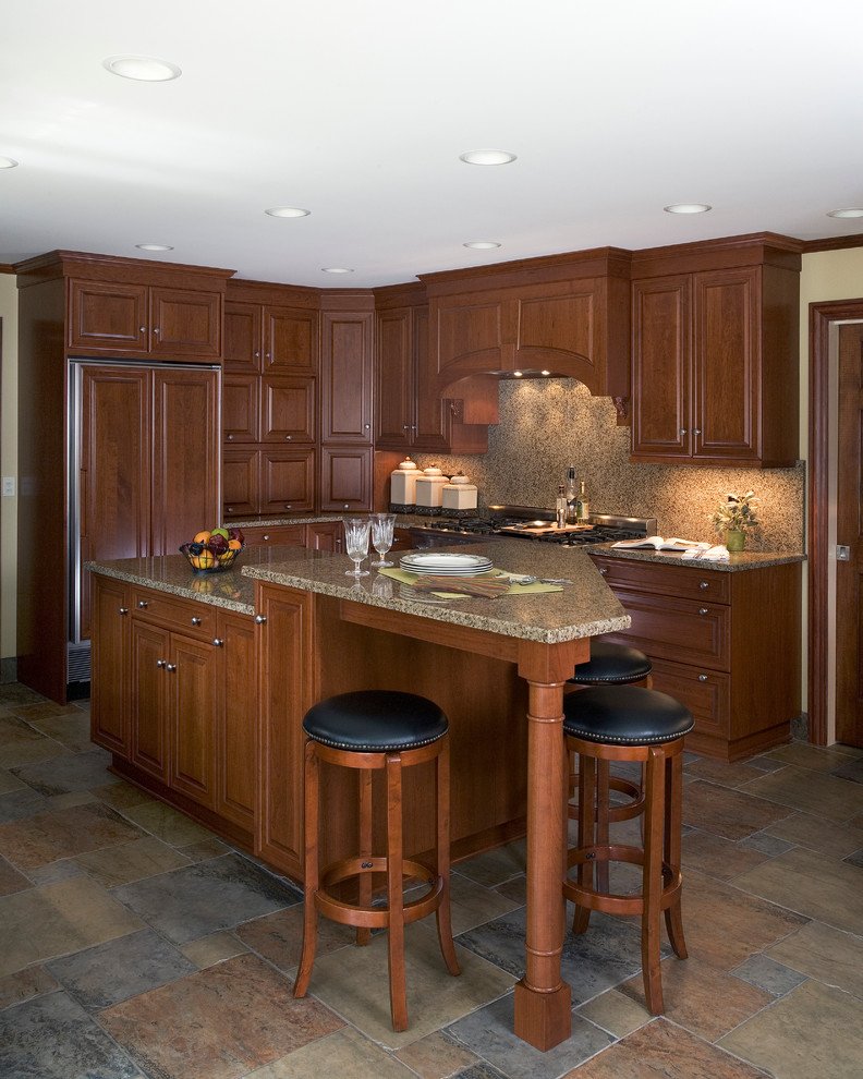 Inredning av ett klassiskt stort kök, med en dubbel diskho, luckor med infälld panel, skåp i mörkt trä, granitbänkskiva, brunt stänkskydd, stänkskydd i sten, rostfria vitvaror, skiffergolv och en köksö