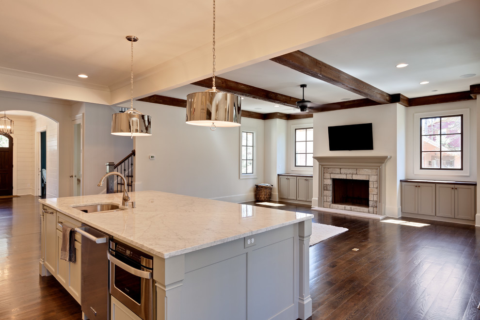 Inspiration for a mid-sized timeless single-wall medium tone wood floor open concept kitchen remodel in Atlanta with an undermount sink, recessed-panel cabinets, white cabinets, marble countertops, multicolored backsplash, stone tile backsplash, paneled appliances and an island