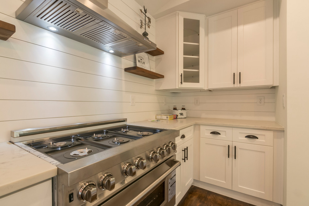 Exempel på ett mellanstort lantligt vit vitt kök, med en rustik diskho, skåp i shakerstil, vita skåp, bänkskiva i kvartsit, vitt stänkskydd, stänkskydd i trä, rostfria vitvaror, mörkt trägolv, en köksö och brunt golv