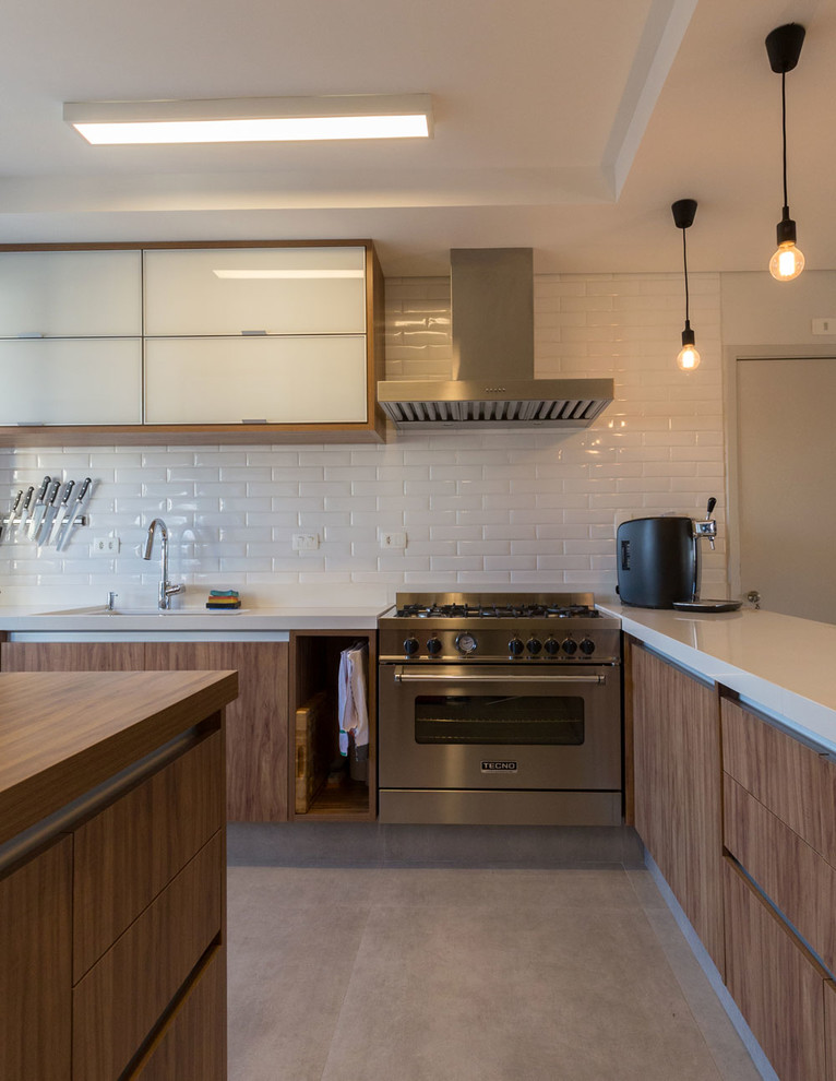 Diseño de cocina contemporánea grande con fregadero de doble seno, armarios tipo vitrina, puertas de armario de madera oscura, encimera de cuarcita, salpicadero blanco, salpicadero de azulejos de cerámica, electrodomésticos de acero inoxidable, suelo de baldosas de porcelana, una isla y suelo gris