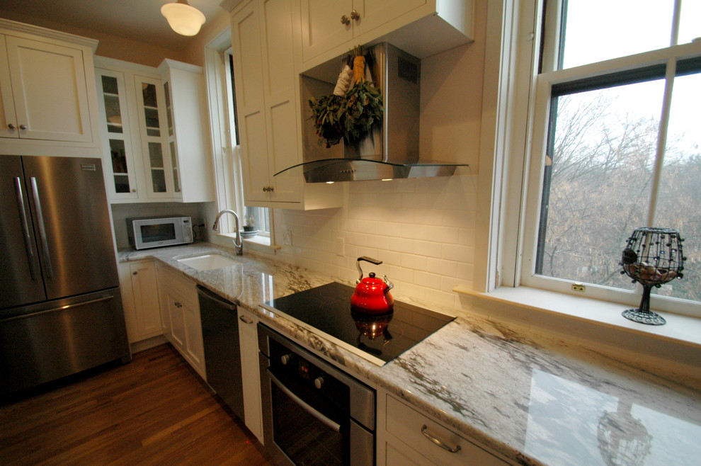 Einzeilige Moderne Wohnküche mit Unterbauwaschbecken, Schrankfronten im Shaker-Stil, weißen Schränken, Granit-Arbeitsplatte, Küchenrückwand in Weiß, Rückwand aus Keramikfliesen und weißen Elektrogeräten in Boston