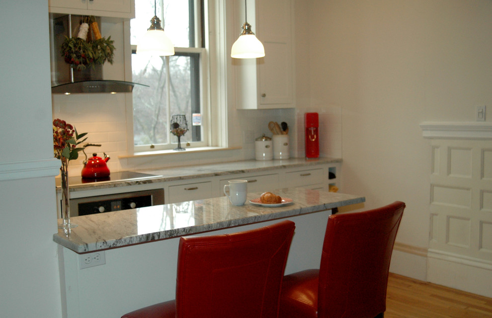 Bild på ett funkis linjärt kök och matrum, med en undermonterad diskho, skåp i shakerstil, vita skåp, granitbänkskiva, vitt stänkskydd, stänkskydd i keramik och vita vitvaror