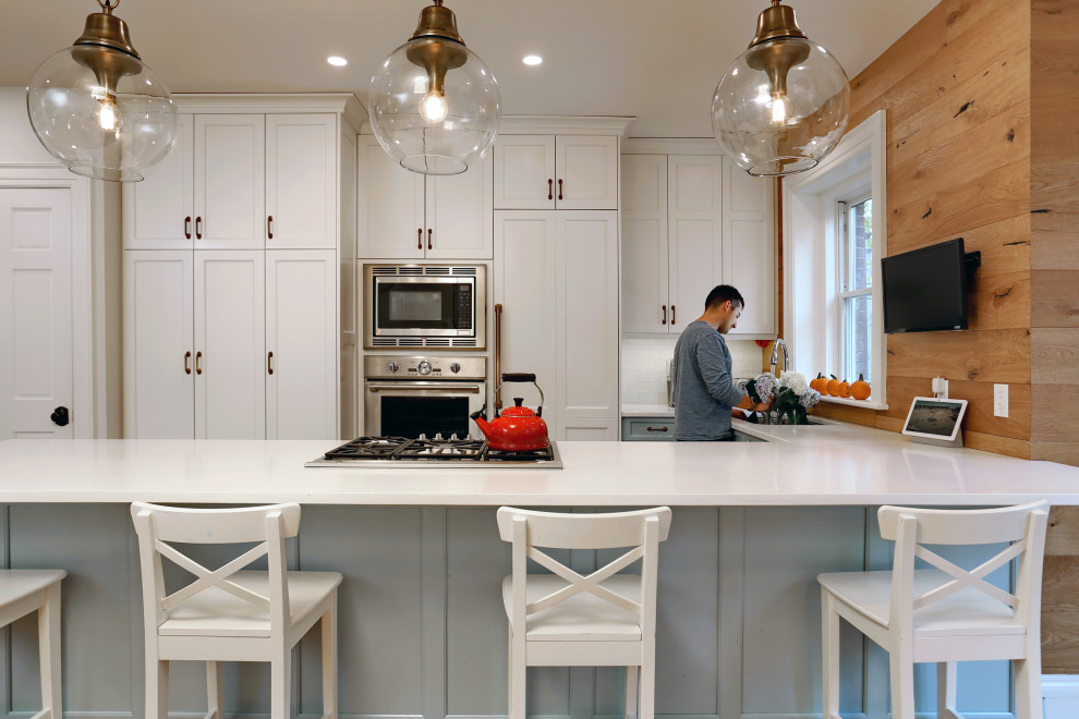 Exempel på ett mellanstort lantligt vit vitt kök, med en undermonterad diskho, luckor med infälld panel, vita skåp, bänkskiva i kvarts, vitt stänkskydd, stänkskydd i keramik, integrerade vitvaror, mellanmörkt trägolv, en halv köksö och brunt golv