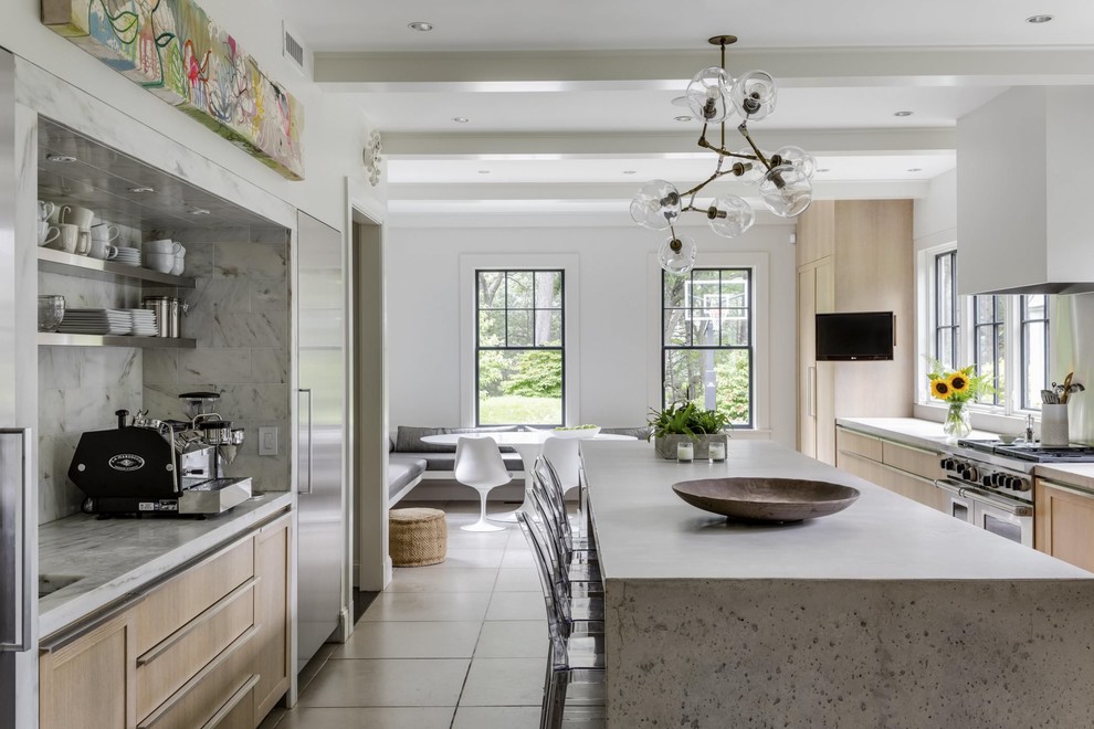 Foto på ett funkis grå kök, med luckor med infälld panel, skåp i ljust trä, bänkskiva i betong, grått stänkskydd, rostfria vitvaror, en köksö och grått golv