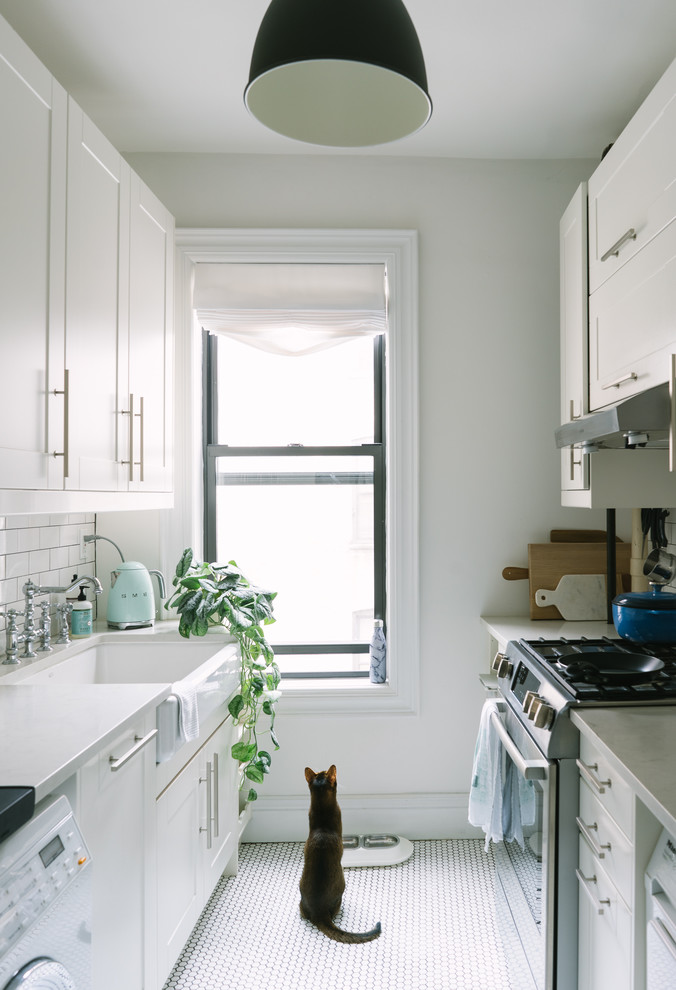 Modelo de cocina escandinava con fregadero sobremueble, armarios estilo shaker, puertas de armario blancas, salpicadero blanco, salpicadero de azulejos tipo metro y suelo blanco