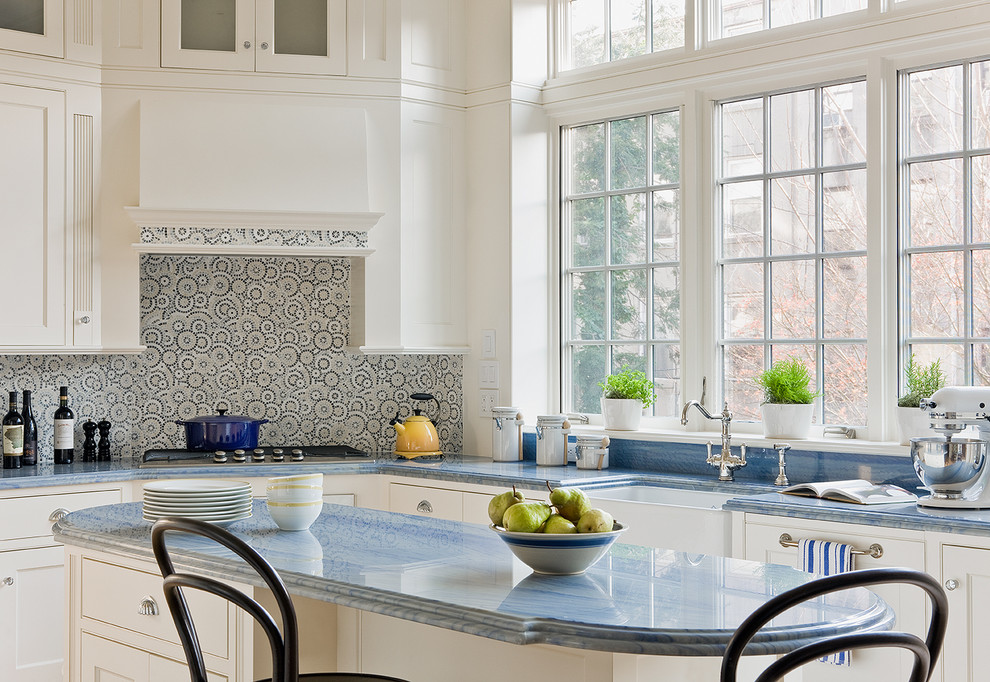 Eat-in kitchen - traditional l-shaped eat-in kitchen idea in New York with a farmhouse sink, white cabinets, beaded inset cabinets, marble countertops, multicolored backsplash and blue countertops