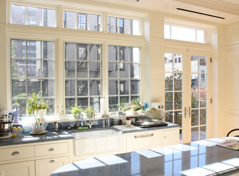 На фото: угловая кухня в классическом стиле с обеденным столом, с полувстраиваемой мойкой (с передним бортиком), фасадами в стиле шейкер, белыми фасадами, мраморной столешницей, синим фартуком и фартуком из каменной плиты с