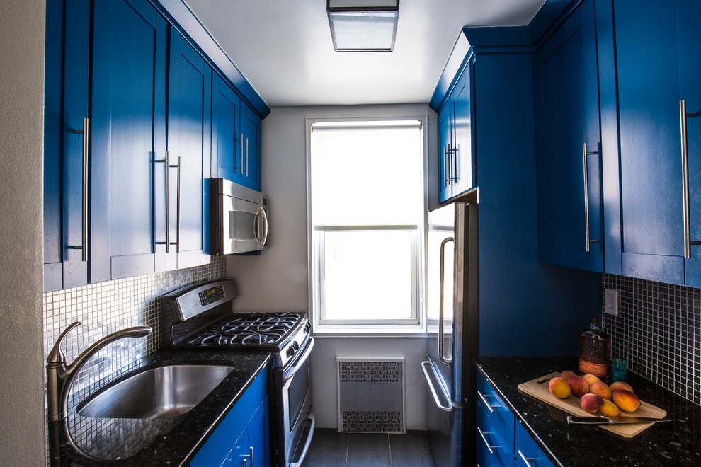 ニューヨークにあるお手頃価格の小さなエクレクティックスタイルのおしゃれなキッチン (アンダーカウンターシンク、シェーカースタイル扉のキャビネット、青いキャビネット、クオーツストーンカウンター、グレーのキッチンパネル、モザイクタイルのキッチンパネル、シルバーの調理設備、セラミックタイルの床、アイランドなし) の写真
