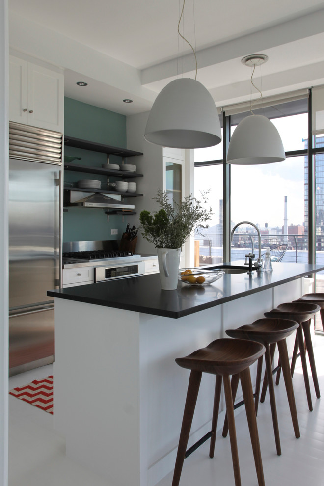 Foto di una cucina parallela design con lavello sottopiano, ante in stile shaker, ante bianche e elettrodomestici in acciaio inossidabile