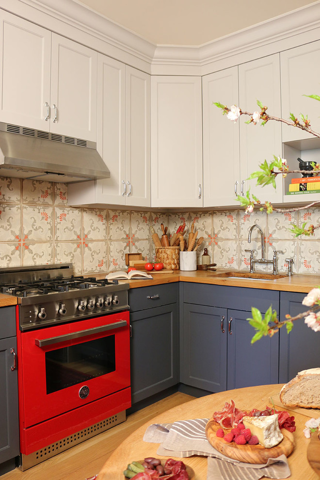 Exempel på ett mellanstort lantligt kök, med en undermonterad diskho, luckor med infälld panel, blå skåp, träbänkskiva, flerfärgad stänkskydd, färgglada vitvaror, ljust trägolv och beiget golv