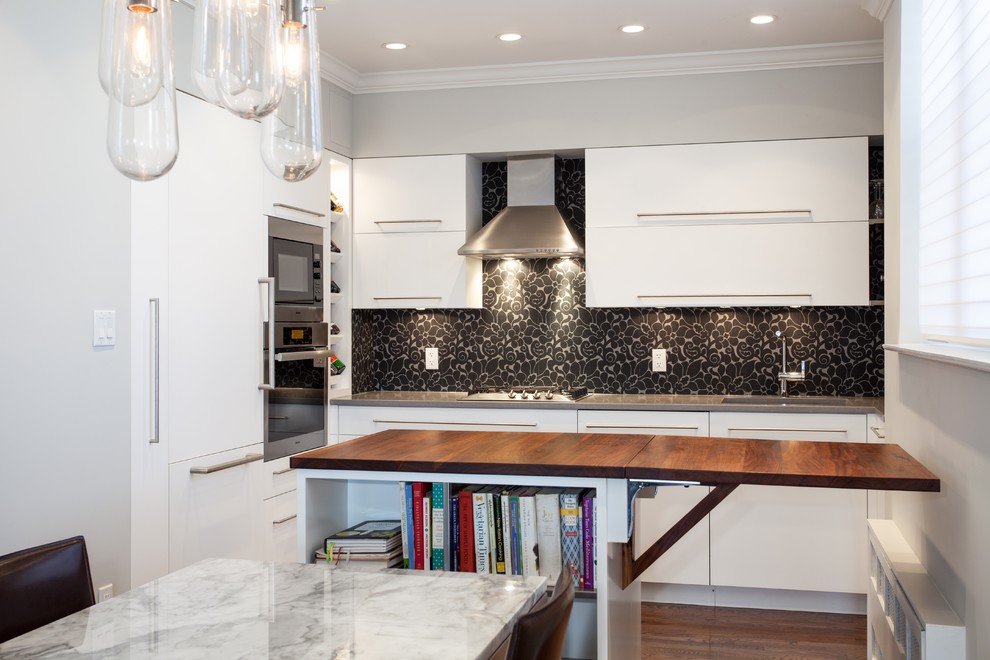 Example of a trendy u-shaped eat-in kitchen design in New York with an undermount sink, flat-panel cabinets, white cabinets, quartz countertops, multicolored backsplash and paneled appliances