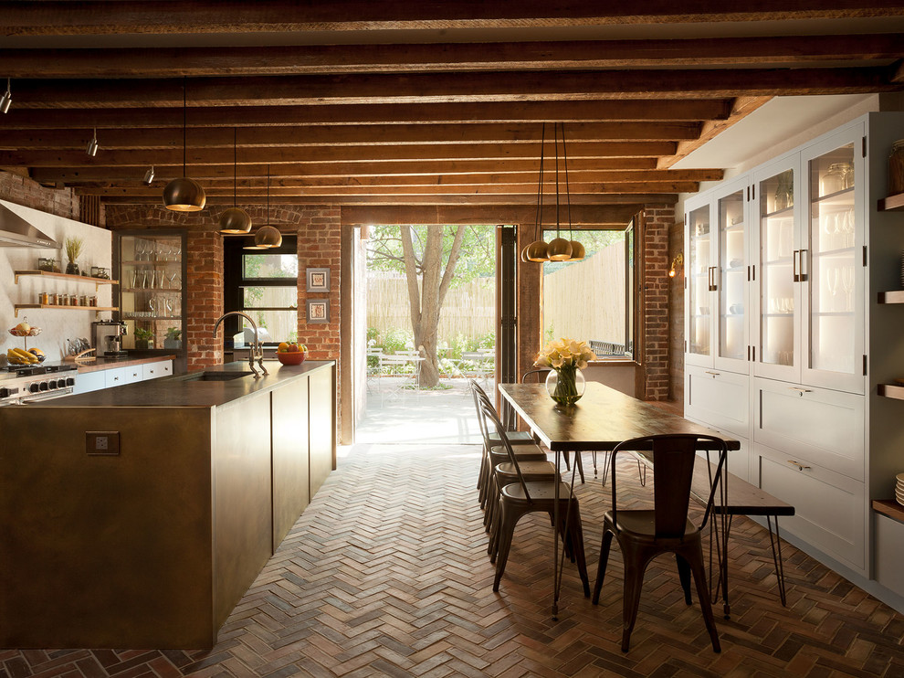 Bild på ett rustikt brun brunt kök, med luckor med glaspanel, vita skåp, rostfria vitvaror, tegelgolv, en köksö, en integrerad diskho, träbänkskiva, vitt stänkskydd och rött golv
