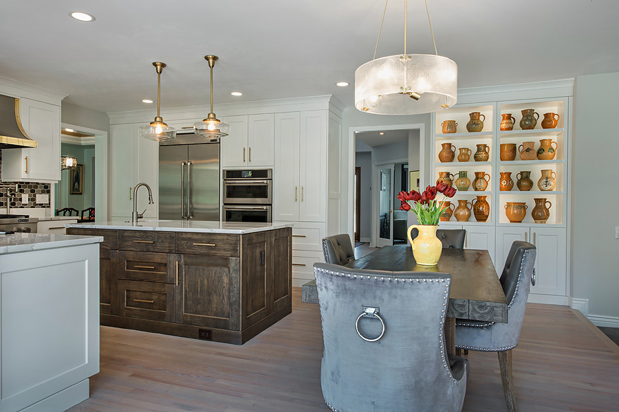 Inspiration for a large transitional u-shaped light wood floor and brown floor eat-in kitchen remodel in Denver with a drop-in sink, shaker cabinets, white cabinets, quartzite countertops, multicolored backsplash, ceramic backsplash, stainless steel appliances and an island