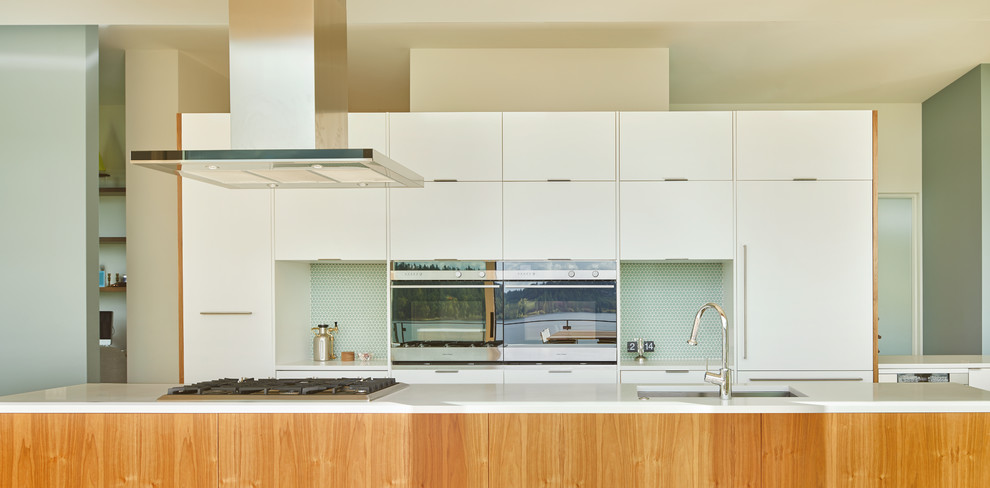Retro Wohnküche in L-Form mit flächenbündigen Schrankfronten, hellbraunen Holzschränken, Quarzwerkstein-Arbeitsplatte, Küchenrückwand in Blau und Kücheninsel in Seattle