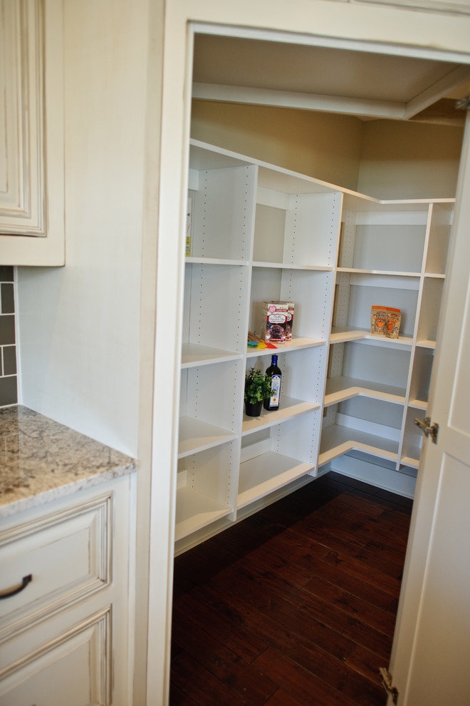 Photo of a classic u-shaped kitchen pantry in Indianapolis with open cabinets, white cabinets and dark hardwood flooring.
