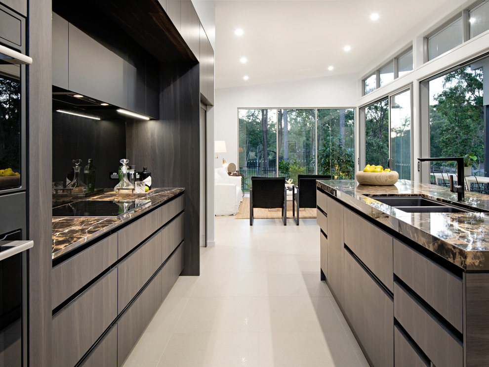 Modern inredning av ett mellanstort svart svart kök, med en undermonterad diskho, släta luckor, skåp i mörkt trä, granitbänkskiva, svart stänkskydd, glaspanel som stänkskydd, svarta vitvaror, klinkergolv i porslin, en köksö och beiget golv