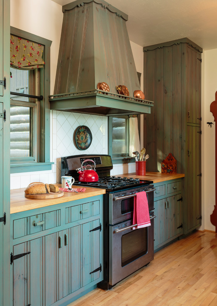 Idéer för att renovera ett lantligt kök, med luckor med profilerade fronter, blå skåp, träbänkskiva, vitt stänkskydd och rostfria vitvaror