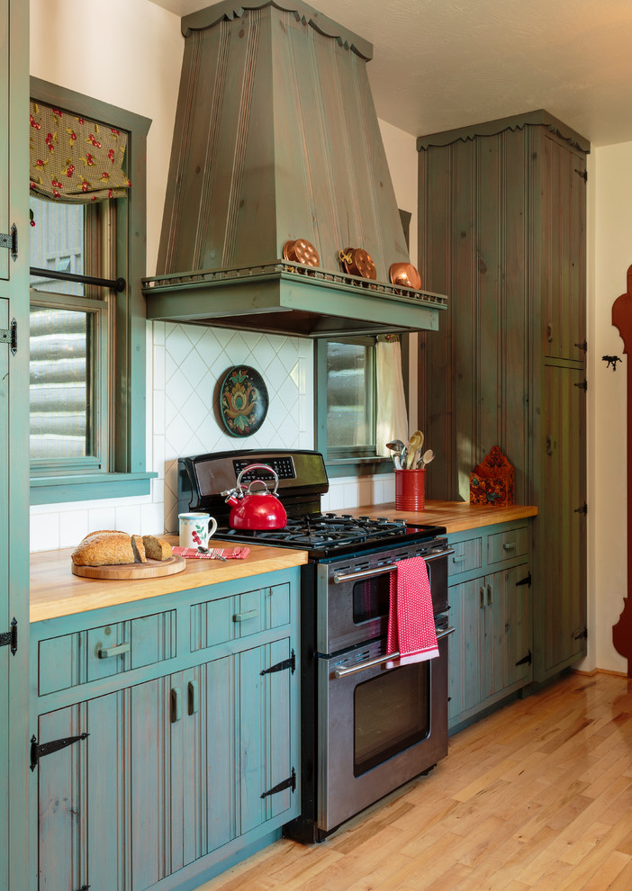 Farmhouse kitchen photo in Milwaukee with beaded inset cabinets, blue cabinets, wood countertops, white backsplash and stainless steel appliances