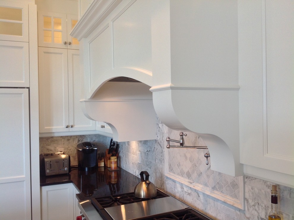 This is an example of a large classic u-shaped open plan kitchen in Montreal with a submerged sink, shaker cabinets, white cabinets, engineered stone countertops, grey splashback, mosaic tiled splashback, integrated appliances, dark hardwood flooring and an island.