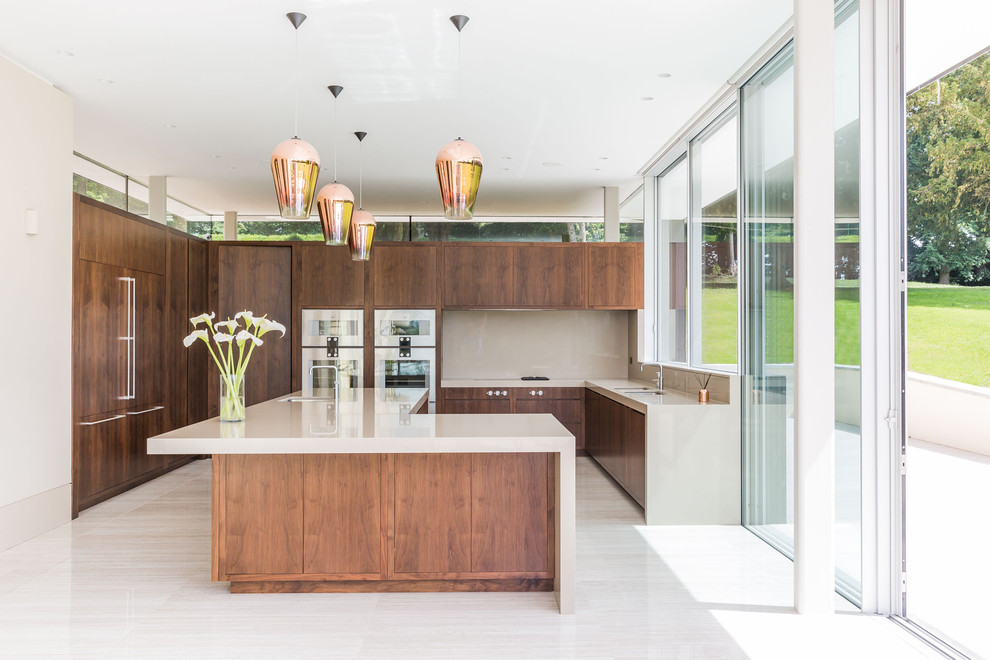 Medium sized contemporary l-shaped kitchen in Kent with a double-bowl sink, flat-panel cabinets, dark wood cabinets, limestone worktops, an island and white floors.
