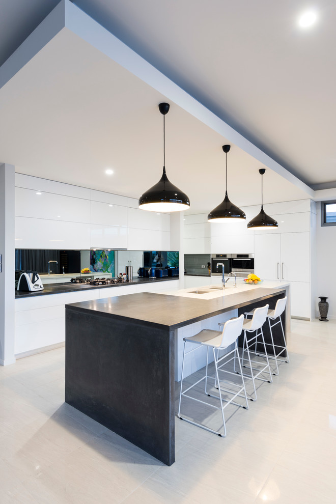 Inspiration for a medium sized contemporary galley kitchen in Gold Coast - Tweed with a submerged sink, flat-panel cabinets, white cabinets, stainless steel appliances and an island.
