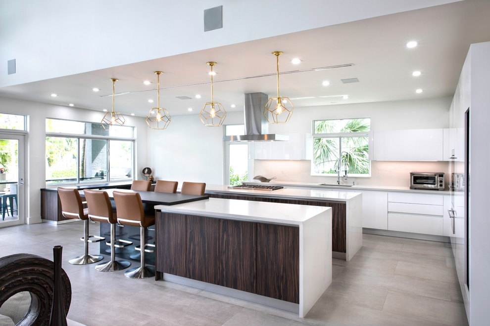 Open concept kitchen - contemporary open concept kitchen idea in Miami with an undermount sink, flat-panel cabinets, white cabinets, gray backsplash, glass sheet backsplash, two islands and gray countertops
