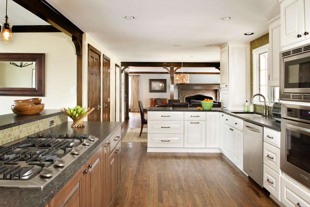 Imagen de cocina clásica con armarios con paneles con relieve, puertas de armario blancas y electrodomésticos de acero inoxidable