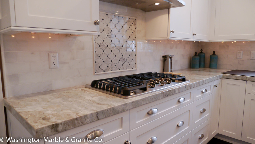 Inredning av ett modernt mellanstort kök, med en undermonterad diskho, släta luckor, gula skåp, marmorbänkskiva, svart stänkskydd, stänkskydd i stenkakel, rostfria vitvaror, mörkt trägolv och flera köksöar