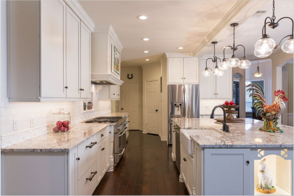Exempel på ett klassiskt kök, med en undermonterad diskho, granitbänkskiva, vitt stänkskydd och rostfria vitvaror