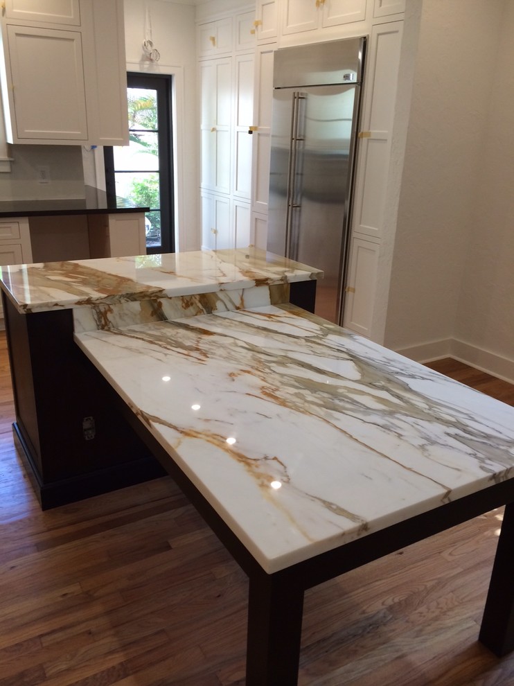 Inspiration for a mid-sized contemporary l-shaped medium tone wood floor kitchen remodel in Miami with an undermount sink, dark wood cabinets, quartz countertops, stainless steel appliances and an island