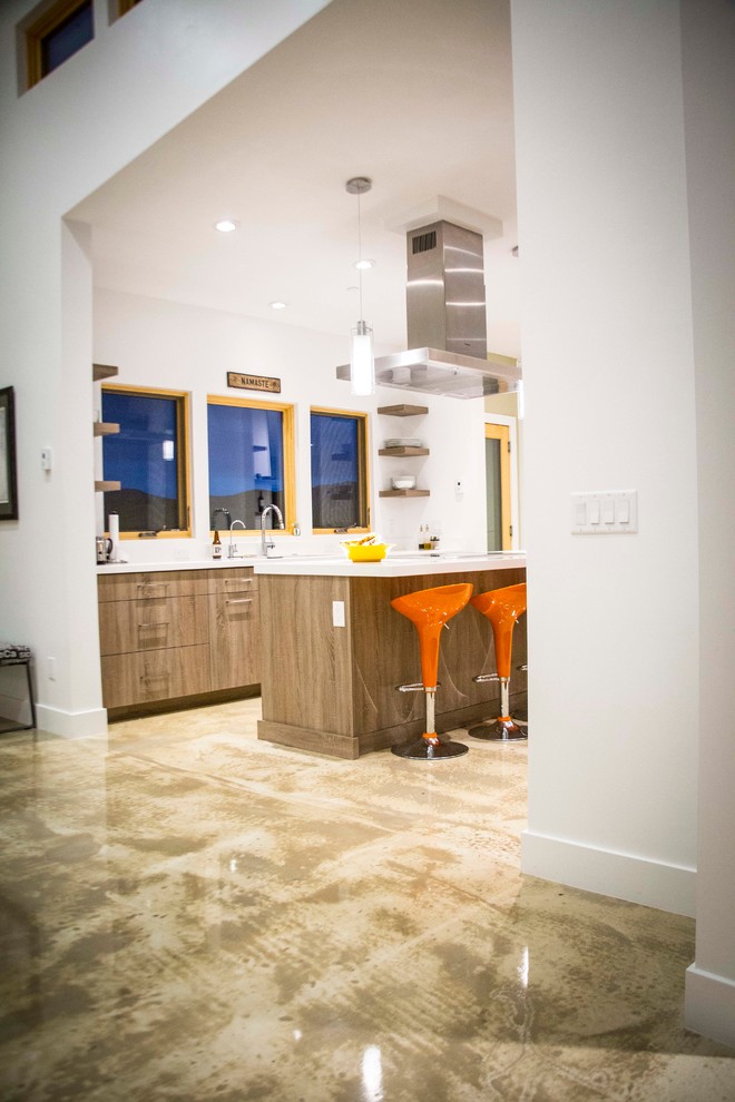 Foto på ett mellanstort funkis vit kök, med en undermonterad diskho, släta luckor, skåp i mellenmörkt trä, bänkskiva i kvarts, rostfria vitvaror, betonggolv och en köksö